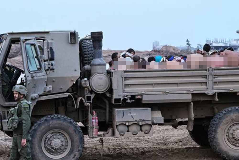 Tahanan warga Palestin menaiki trak tentera Israel sebelum dimasukkan ke penjara tentera Ofer di Tebing Barat. - Foto Agensi