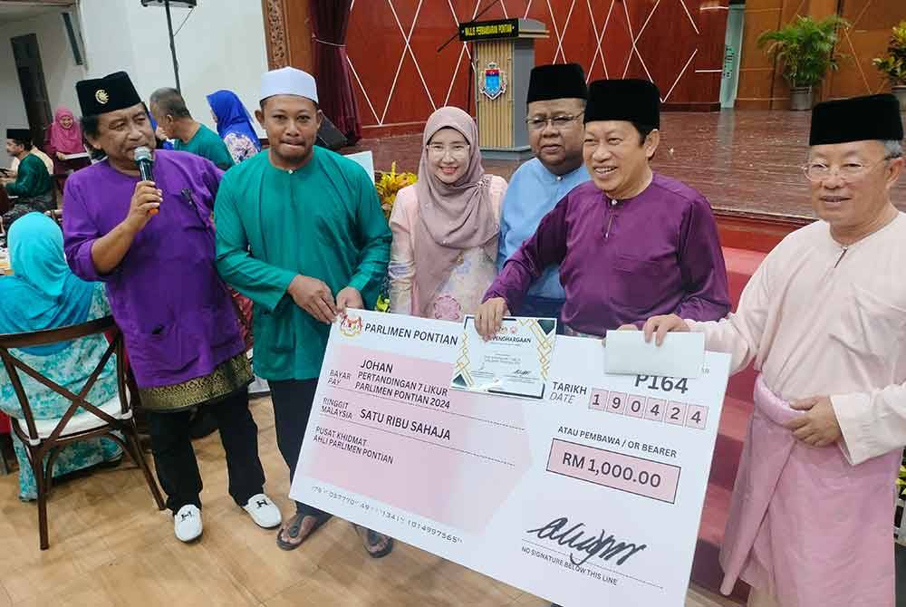 Ahmad (dua dari kanan) menyampaikan hadiah kepada pemenang pertandingan tujuh likur di Dewan Jubli Intan Pontian pada Jumaat.