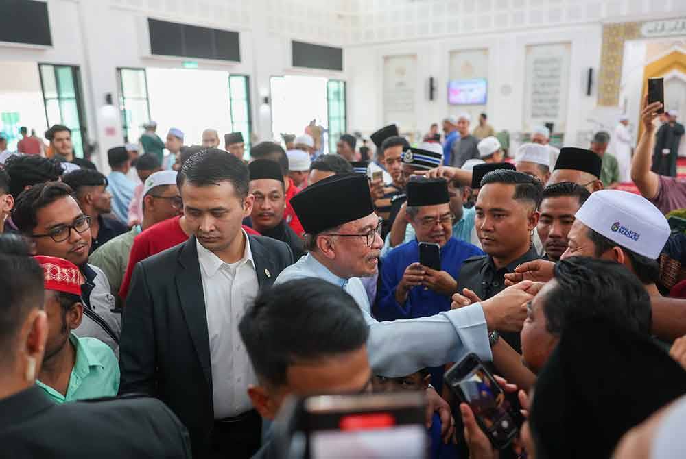 Anwar beramah mesra dengan jemaah yang hadir sebelum menunaikan solat Jumaat bersama rakyat di Masjid Bandar Teknologi Kajang hari ini. Foto Bernama