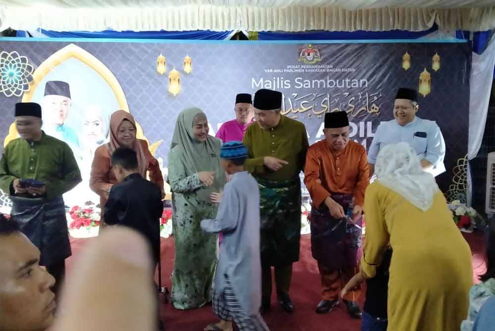 Ahmad Zahid (tengah) menyampaikan duit raya kepada kanak-kanak yang hadir sempena Majlis Sambutan Hari Raya Aidilfitri 2024 anjuran beliau di pekarangan Kompleks UMNO Bagan Datuk di sini, pada Jumaat.