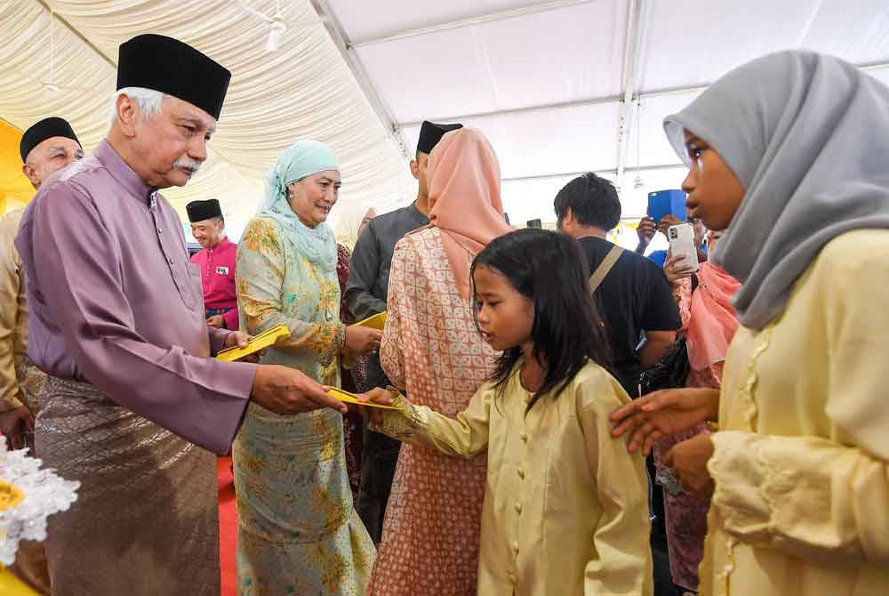 Yang di-Pertuan Besar Negeri Sembilan, Tuanku Muhriz Tuanku Munawir (kiri) dan Tunku Ampuan Besar, Tuanku Aishah Rohani Tengku Besar Mahmud (dua dari kiri) berkenan memberi sumbangan duit raya kepada kanak-kanak yang menghadiri Majlis Istana Terbuka sempena Aidilfitri di Istana Besar Seri Menanti baru-baru ini.