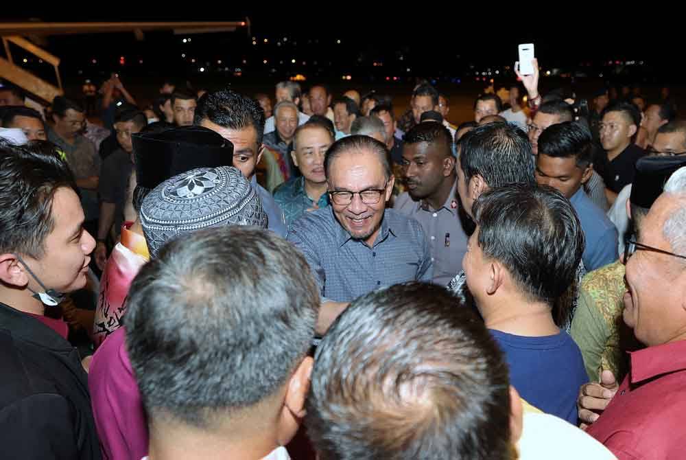 Anwar bersalaman dengan orang ramai yang menyambut ketibaannya di Terminal 2 Lapangan Terbang Antarabangsa Kota Kinabalu hari ini. Foto Bernama