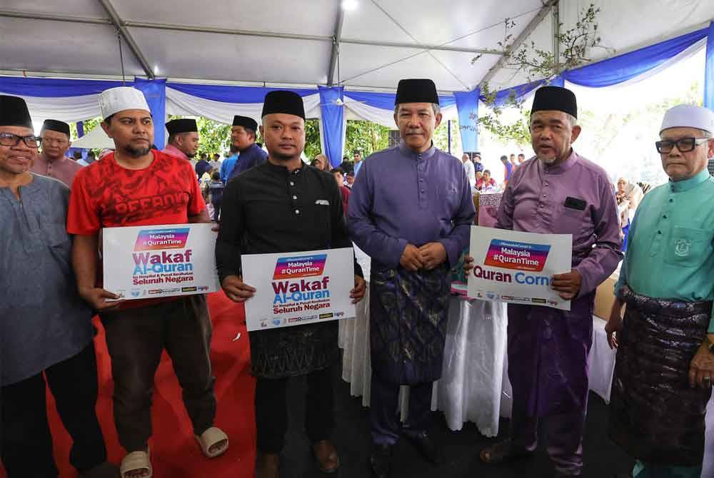 Mohamad (empat dari kiri) dan Hashim (dua dari kanan) bersama wakil masjid dan surau yang hadir menerima al-Quran wakaf itu pada Sabtu.