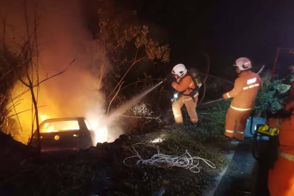 Bomba memadamkan kenderaan mangsa yang terbakar selepas terjunam ke dalam gaung.