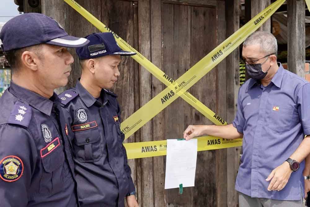 Mohd Zary (kanan) bersama-sama penguatkuasa menjalankan tindakan penguatkuasaan di tapak tanah rizab sekolah, Jalan Langat, Bandar Botanik di sini pada 17 April lalu.