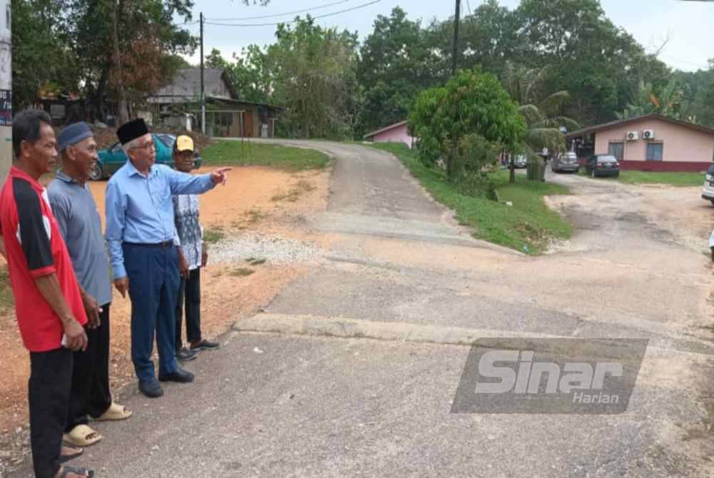 Ahli Parlimen Pasir Gudang, Hassan Abdul Karim (tiga dari kiri) melihat keadaan jalan yang rosak di Kampung Sungai Rinting B, Pasir Gudang pada Isnin.