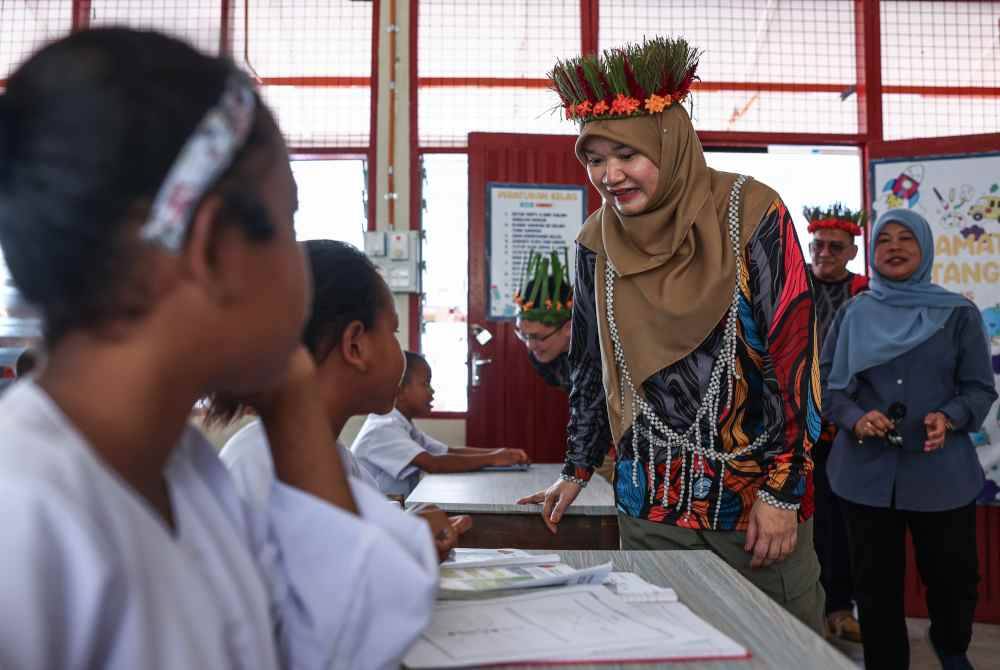 Fadhlina menyantuni murid-murid orang asli ketika hadir membuat lawatan ke Sekolah Kebangsaan Sri Permai JHEOA Komprehensif 9 (K9), Gua Musang sempena Jelajah Pendidikan Madani Sekolah Murid Orang Asli hari ini. Foto Bernama