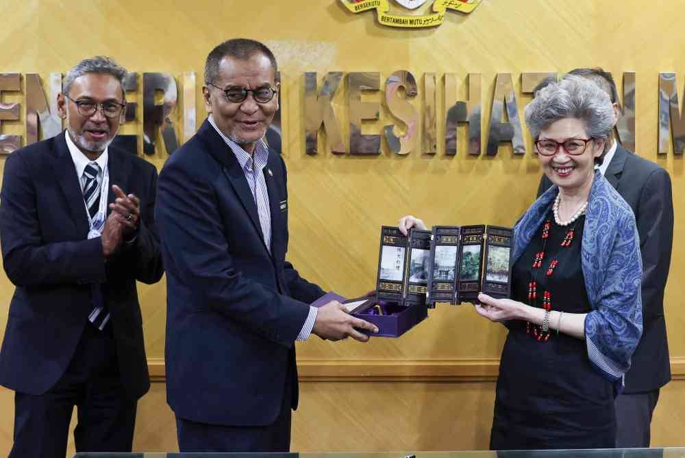 Dr Dzulkefly menerima cenderahati daripada Pengarah Pejabat Pengurusan Penyelidikan Klinikal Chinese Universiti of Hong Kong (CUHK), Prof Juliana Chan selepas menyaksikan majlis menandatangani perjanjian memorandum persefahaman antara Clinical Research Malaysia (CRM) dengan Chinese Universiti of Hong Kong (CUHK) bagi usaha sama dalam bidang klinikal, akademik dan prospek penyelidikan, di Kementerian Kesihatan hari ini. Foto Bernama