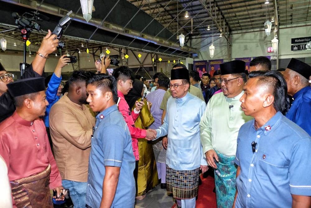 Anwar (tengah ) bersalaman dengan orang ramai pada Majlis Sambutan Aidilfitri 2024 peringkat negeri Melaka di MITC Ayer Keroh, di sini, pada malam Isnin.