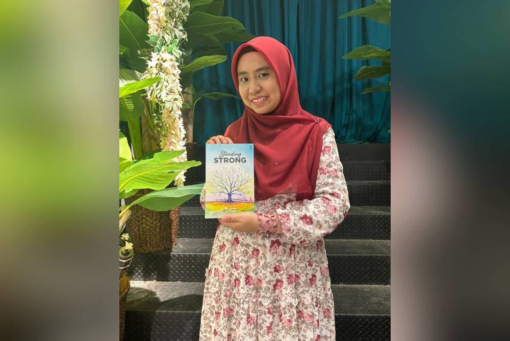 Syira bergambar bersama karyanya ketujuh iaitu Standing Strong yang dilancarkan pada Isnin.