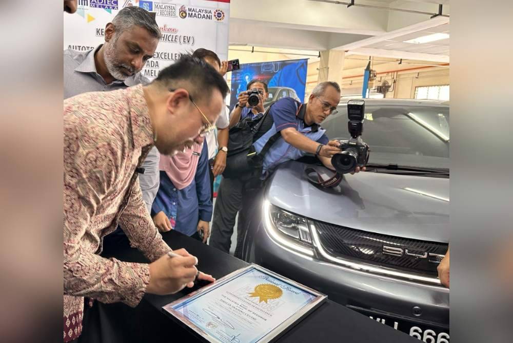 P Sri Ganes (kiri) menyaksikan Menteri Sumber Manusia, Steven Sim Chee Keong menyempurnakan majlis menandatangani papan tanda dan penyerahan kenderaan EV oleh Autotronics Center of Excellence Sdn Bhd kepada ADTEC Melaka pada Isnin.