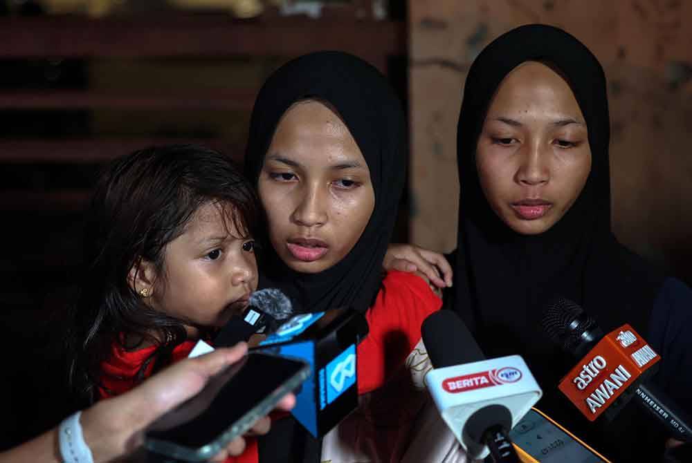 Kembar, Nur Qistina Awliyah (dua dari kiri) dan Nur Qistina Auni (kiri), kedua-duanya 16 tahun anak kepada Nor Rahiza, 39, ketika ditemui media di Unit Perubatan Forensik Hospital Raja Permaisuri Bainun hari ini. Foto Bernama