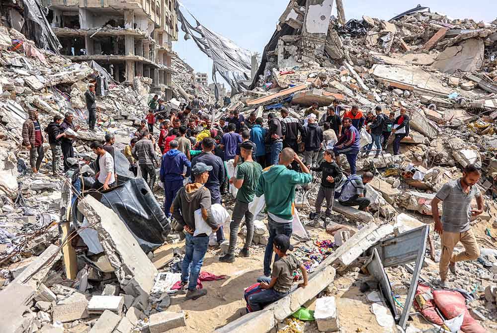 Orang ramai berkumpul di tepi bangunan yang musnah di tapak penurunan bantuan kemanusiaan di utara Semenanjung Gaza pada Isnin. Foto AFP