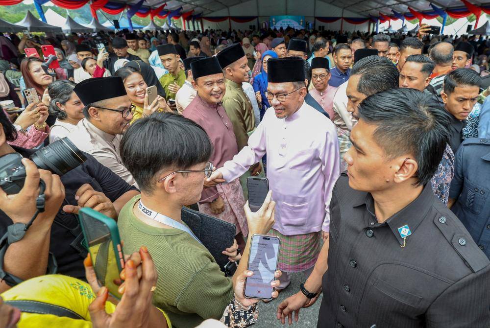 Anwar bersalaman dengan warga KPT semasa menghadiri majlis Riang Ria Raya KPT hari ini. Foto Bernama