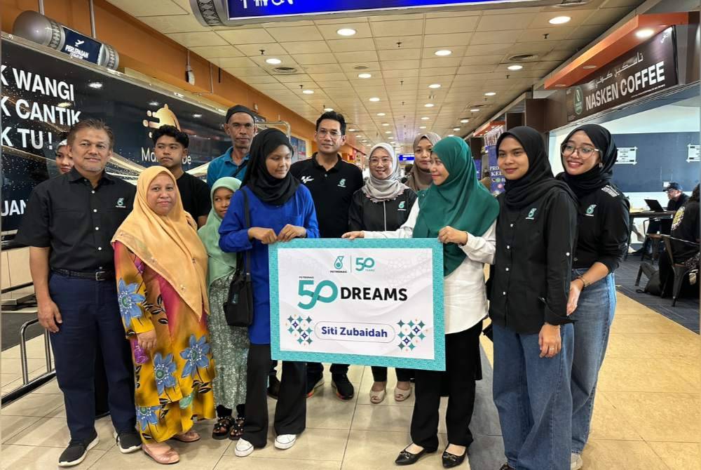 Simbolik penyerahan Petronas 50 Dreams kepada Siti Zubaidah sekeluarga.