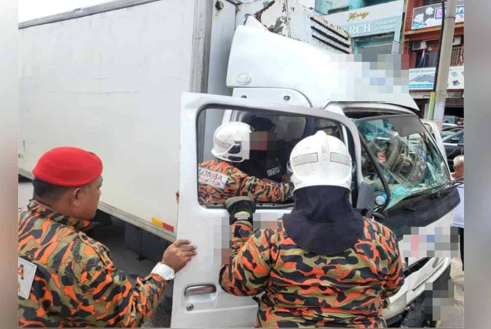 Anggota bomba cuba mengeluarkan mangsa yang tersepit dalam kemalangan berkenaan. - Foto ihsan BBP Kluang