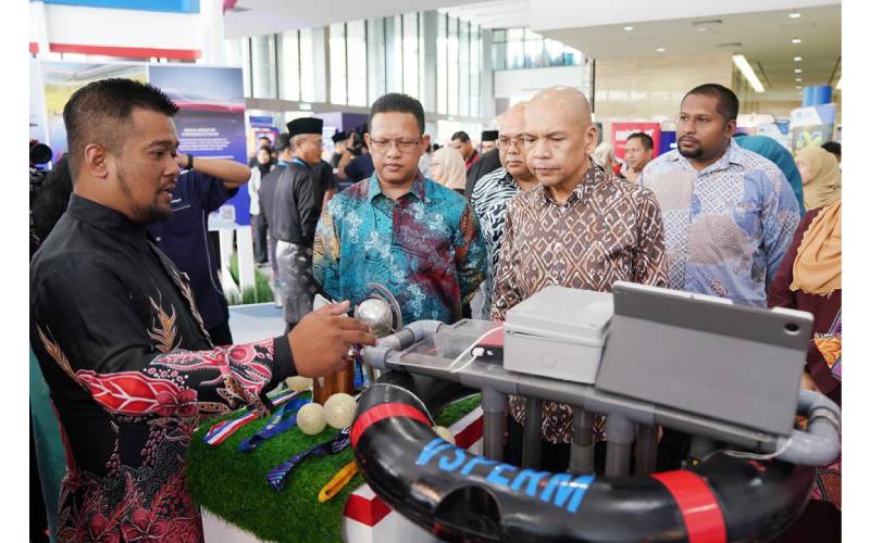 Armizan (kanan) bersama Mohd Zuhan (dua, kiri) mendengar penerangan daripada seorang pempamer yang menyertai pameran harta intelek sempena sambutan HHIN 2024 di Menara MyIPO, Petaling Jaya pada Jumaat.