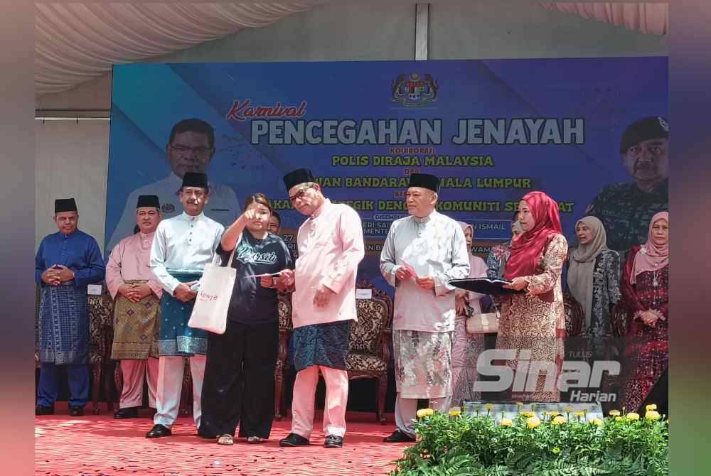 Saifuddin (tengah) mendengar penerangan daripada salah seorang mangsa kebakaran di perumahan awam Flat Sri Sabah, Cheras, Kuala Lumpur semasa menerima sumbangan di Karnival Pencegahan Jenayah pada Sabtu. - FOTO:SINAR HARIAN/HISYAMUDDIN AYUB