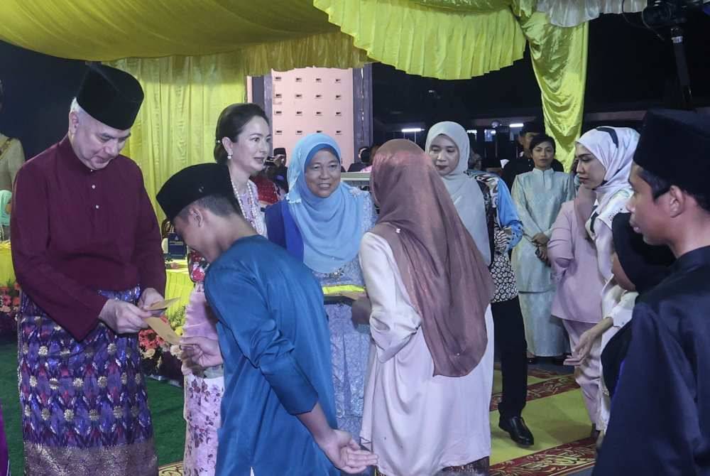 Sultan Nazrin dan Tuanku Zara berkenan menyampaikan duit raya kepada kanak-kanak yang hadir pada Sambutan Hari Raya Aidilfitri PDRM Perak pada Sabtu.