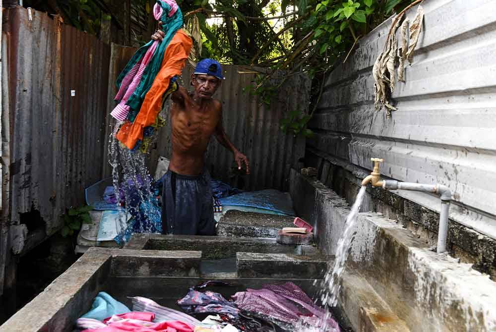 Seorang pekerja Dobi, Ghanapathy melakukan kerja-kerja membasuh pakaian di perkampungan dobi yang terletak di antara Jalan Air Hitam dan Jalan York, Dhobi Ghat. Foto Bernama