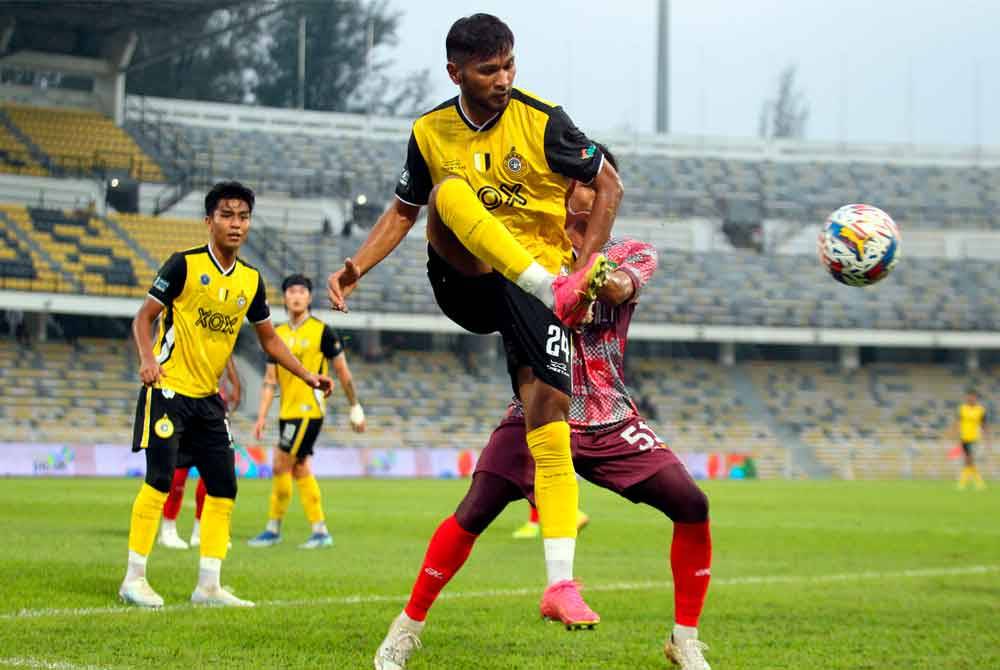 Pemain Perak FC, Mohd Syukri Baharun (depan) bersaing dengan tonggak KDA FC, Mohamad Heshamudin Ahmad dalam perlawanan persahabatan pra-musim 2024/25 di Stadium Perak pada Sabtu. - Foto: Bernama