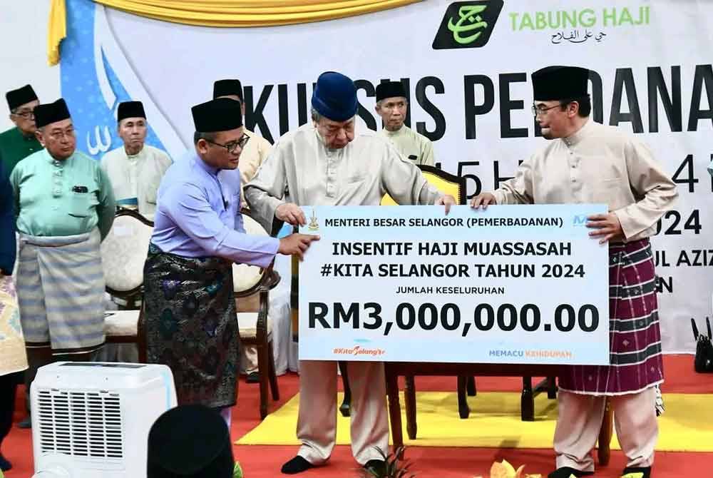 Sultan Selangor (tengah) diiringi Menteri Besar Selangor, Datuk Seri Amirudin Shari (kiri) menyerahkan replika cek insentif haji muassasah #Kita Selangor 2024 kepada Pengarah Jabatan Agama Islam Selangor (JAIS) Datuk Mohd Shahzihan Ahmad (kanan) pada Majlis Penutupan Kursus Perdana Haji Musim 1445 Hijrah di Masjid Sultan Salahuddin Abdul Aziz Shah, Shah Alam.