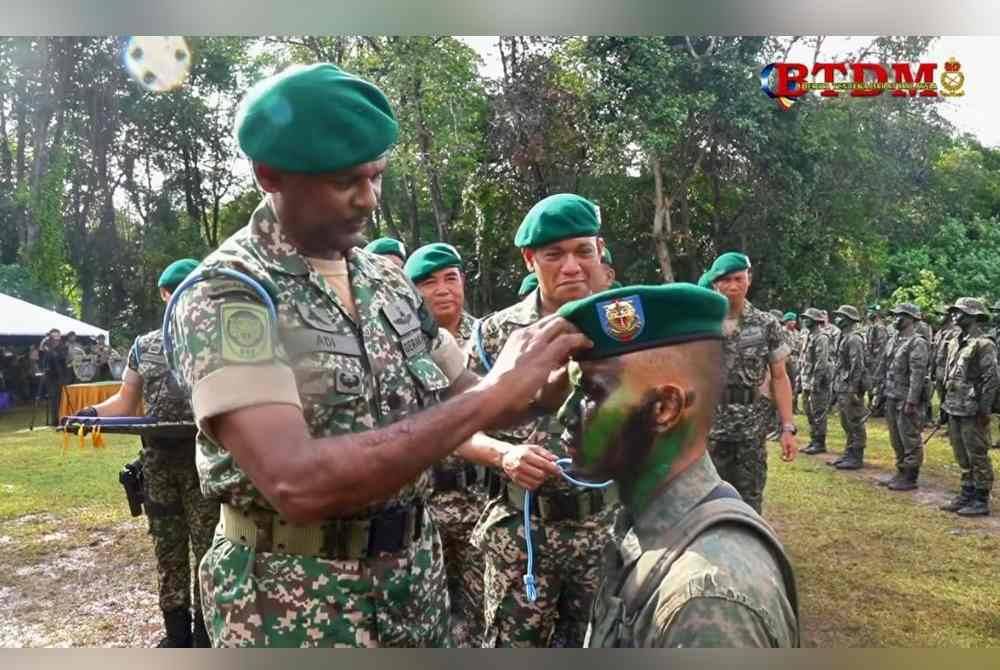 Panglima Grup Gerak Khas (21 GGK), Mejar Jeneral Adi Ridzwan Abdullah menganugerahkan beret hijau dan pisau komando kepada Leftenan Muda Ming Youn. Foto Berita Tentera Darat Malaysia.