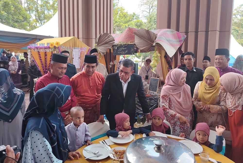 Saifuddin (tengah) beramah mesra dengan anak yatim Pertubuhan Warisan Suci di Putrajaya pada Isnin.