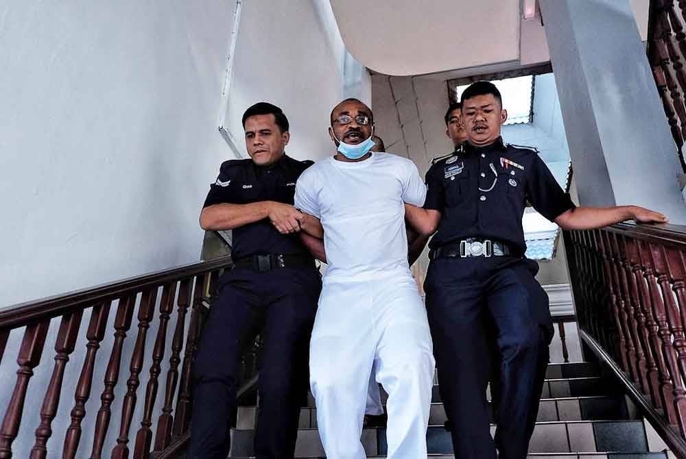 Kebechi Thomas (tengah) bertindak agresif dan menjerit ketika dibawa keluar oleh anggota polis dari Mahkamah Tinggi Melaka pada Isnin.