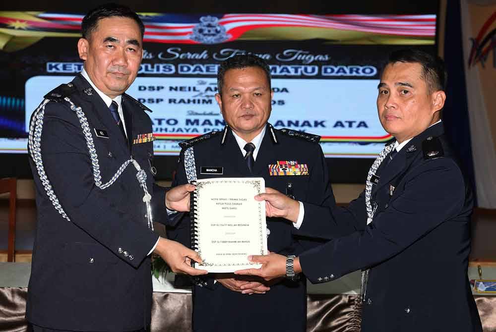 Mancha menyaksikan pertukaran nota serah terima tugas Ketua Polis Daerah Matu Daro Sarawak antara Deputi Superintenden Neil Beginda (kiri) dengan Deputi Superintenden Rahim Mihos pada majlis serah terima tugas Ketua Polis Daerah Padawan, Serian dan Matu Daro di Dewan Mes Pegawai Kanan, Ibu Pejabat Polis Kontinjen (IPK) Sarawak pada Selasa. Foto Bernama