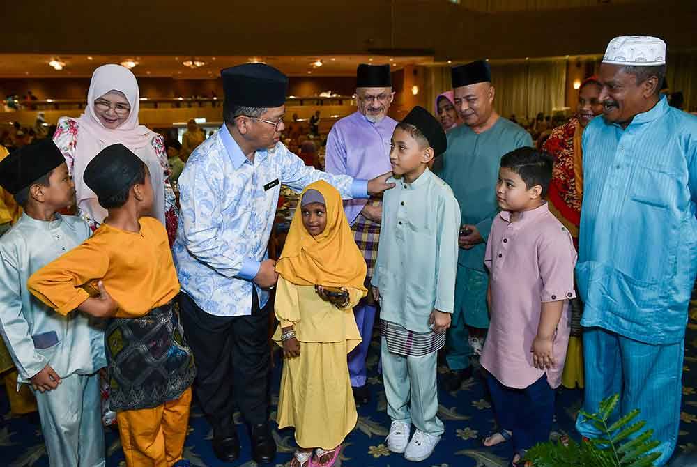 Mohd Na&#039;im (tengah) menyerahkan sumbangan kepada anak-anak asnaf yang hadir pada majlis Rahmah Syawal Majlis Agama Islam Wilayah Persekutuan (MAIWP): Jalinan Aidilfitri Bersama Asnaf MAIWP di Dewan Perdana Felda di Kuala Lumpur pada Selasa. Foto Bernama