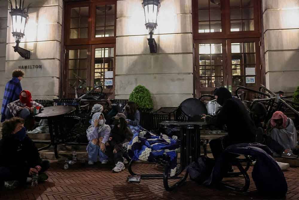 Penunjuk perasaan menyekat pintu masuk dengan meja untuk membentuk penghadang dan melaungkan slogan pro-Palestin. Foto REUTERS