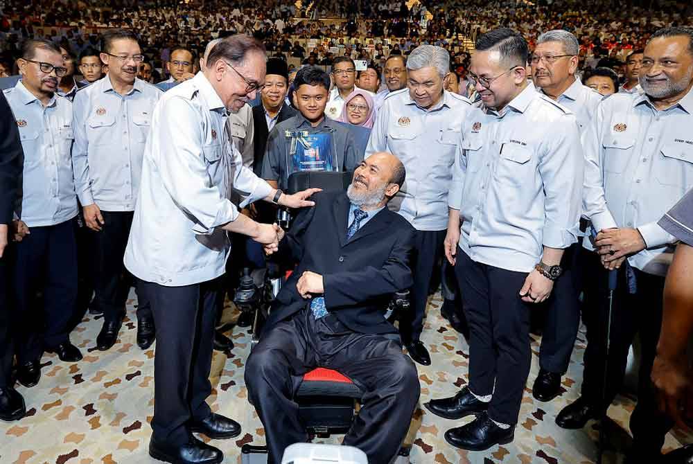 Anwar (kiri) beramah mesra bersama Penerima Anugerah Tokoh Pekerja Negara (OKU) Zaidi Embong pada Majlis Sambutan Hari Pekerja 2024 di Pusat Konvensyen Antarabangsa Putrajaya (PICC) hari ini. - Foto: Bernama