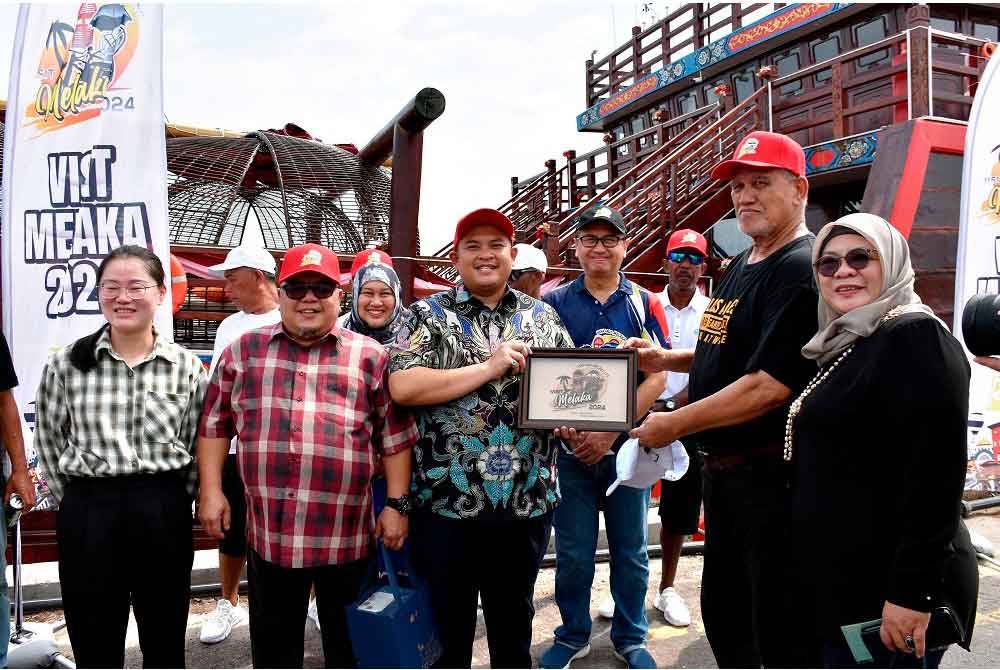 Exco Kanan Perumahan, Kerajaan Tempatan, Saliran, Perubahan Iklim dan Pengurusan Bencana negeri, Datuk Rais Yasin (tengah) menyampaikan cenderahati kepada Kapten Kapal Fu Ning, Abdul Ya Zaid Othman (dua dari kanan) pada Majlis Menyambut Ketibaan Kapal Layar Tradisional Cina Fu Ning Terbesar di Dunia ke Melaka di Pelabuhan Tanjung Bruas di sini hari ini. - Foto: Bernama