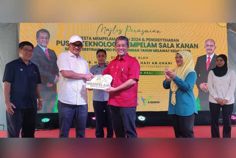 Mohd Salleh (dua dari kiri) menerima cenderahati daripada Dzowahir pada Program Perasmian Fiesta Mempelam Kedah di Pusat Teknologi Mempelam Sala Kanan di Yan pada Khamis.