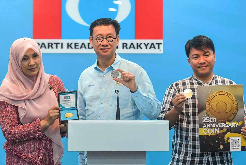 Naib Presiden Parti Keadilan Rakyat (PKR) Nurul Izzah Anwar (kiri) dan Pengarah Sambutan 25 Tahun PKR yang juga Ahli Parlimen Subang Wong Chen (tengah) menunjukkan duit syiling peringatan khas PKR yang memaparkan gambar Perdana Menteri Datuk Seri Anwar Ibrahim ketika sidang media mengenai program sambutan 25 tahun PKR di ibu pejabat PKR pada Jumaat. Foto Bernama