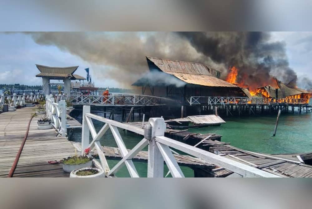 Pasukan bomba berusaha memadamkan kebakaran sebahagian resort di Kampung Tampi-Tampi, Semporna.