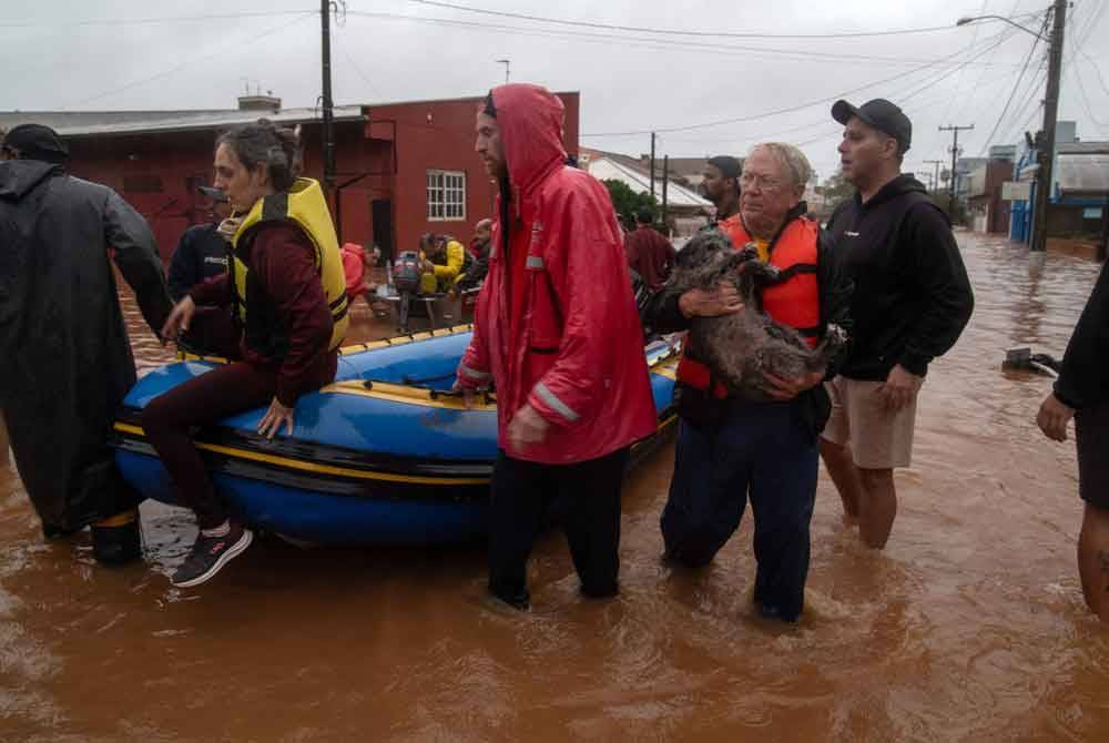 Penduduk dipindahkan dari kawasan banjir di pusat bandar Sao Sebastiao do Cai, Negeri Rio Grande do Sul, Brazil, pada Khamis. Foto AFP