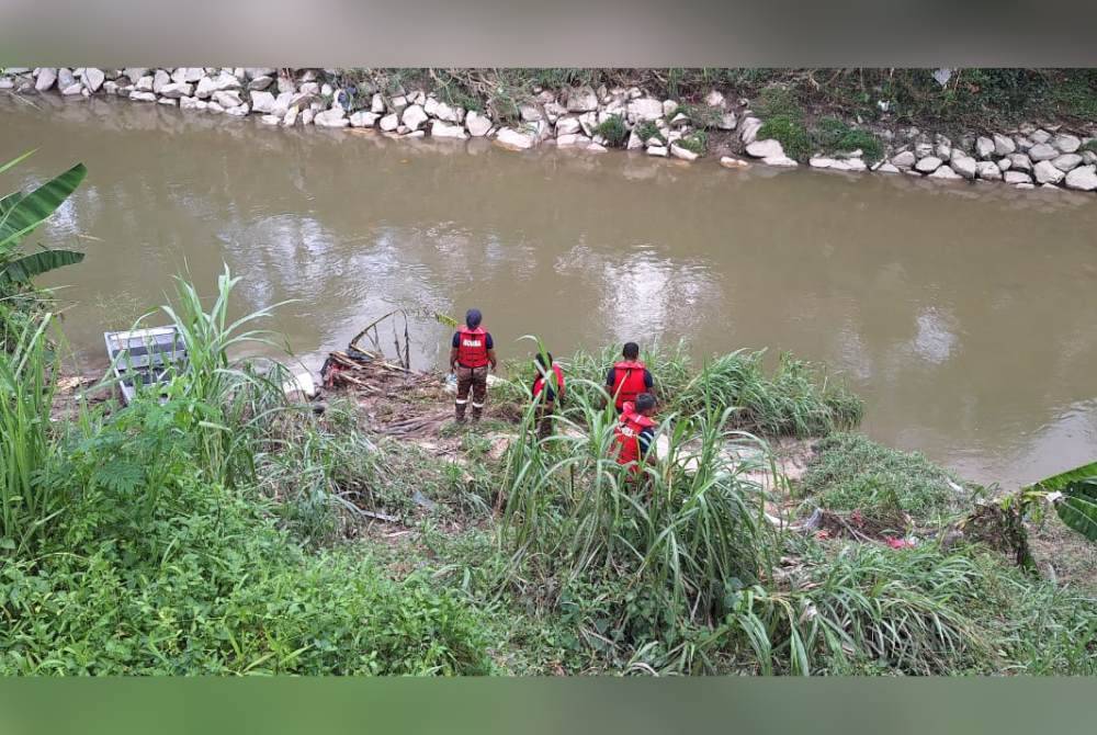 Anggota JBPM membawa naik mangsa warga Pakistan yang ditemukan lemas di Sungai Gasi, Sungai Buloh, Selangor pada Jumaat. Foto JBPM