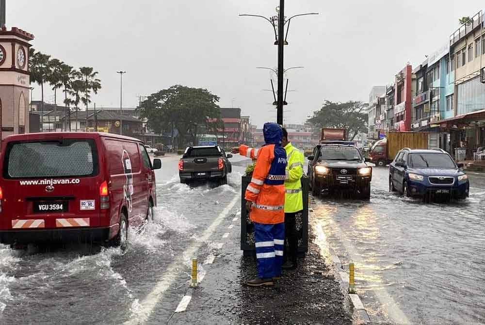 Anggota keselamatan melakukan pemantauan di bandar Kota Tinggi yanh dilanda banjir pada Sabtu. - Foto APM Kota Tinggi.