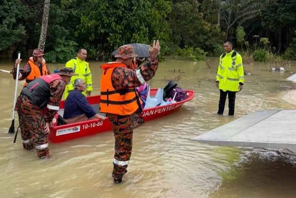 Pasukan penyelamat membantu memindahkan penduduk terjejas banjir ke PPS Sekolah Kebangsaan (SK) Bukit Lintang di Kota Tinggi. - Foto Facebook Polis Kota Tinggi