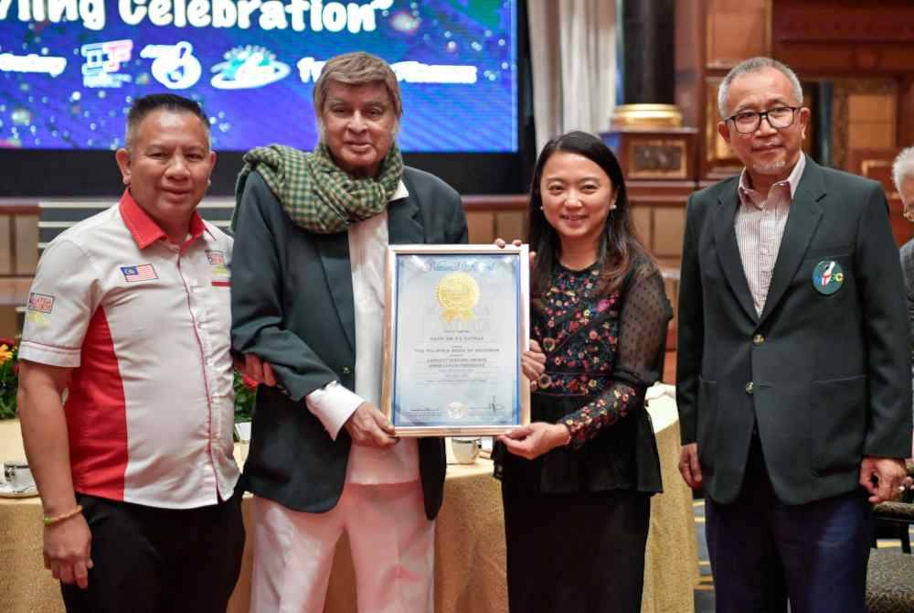 Hannah menyampaikan sijil Malaysia Book of Records P S Nathan (dua, kiri) pada Majlis Makan Malam Ulang Tahun ke-50 Malaysia Tenpin Bowling Congress di Sunway Pyramid malam ini.