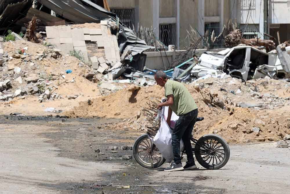 Lelaki Palestin ini menolak basikal di Selatan Gaza. Foto AFP