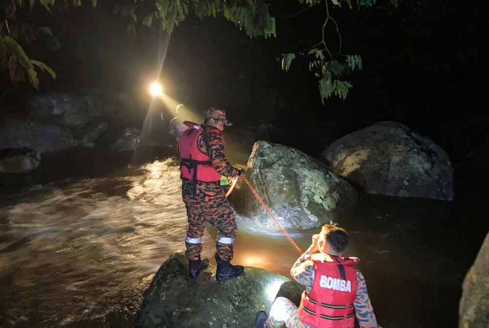 Anggota bomba melakukan kerja penyelamatan menggunakan tali sebelum kedua-dua mangsa berjaya diselamatkan tanpa sebarang kecederaan. Foto Bomba Perak