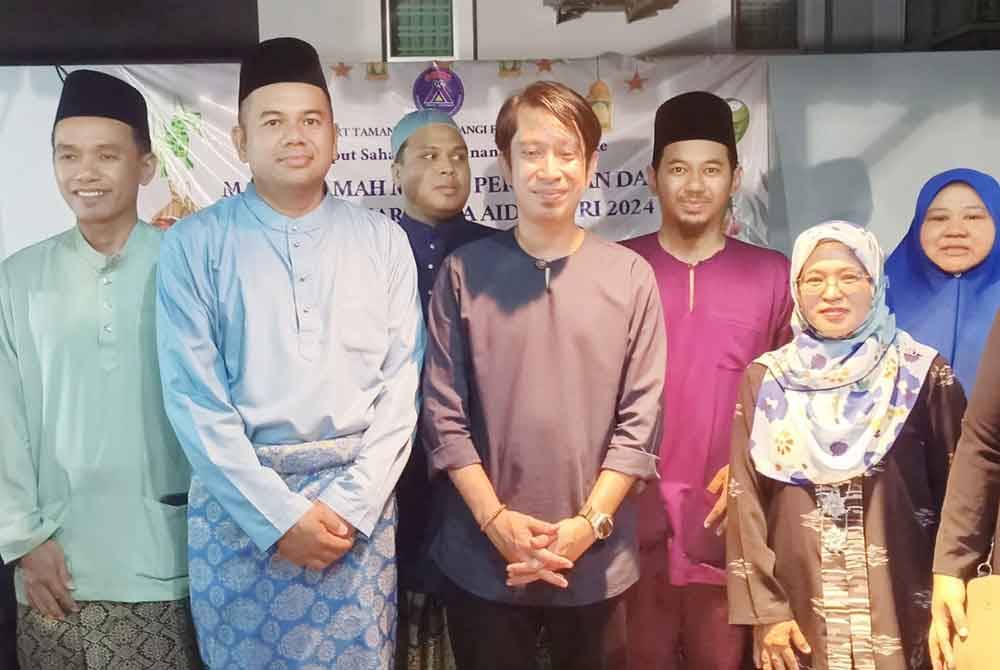 Anuar (dua dari kiri) dan Adam (tengah) bergambar bersama sebahagian AJK Taman Sutera Wangi Fasa Baharu ketika majlis itu, di Batu Berendam, pada malam Jumaat.