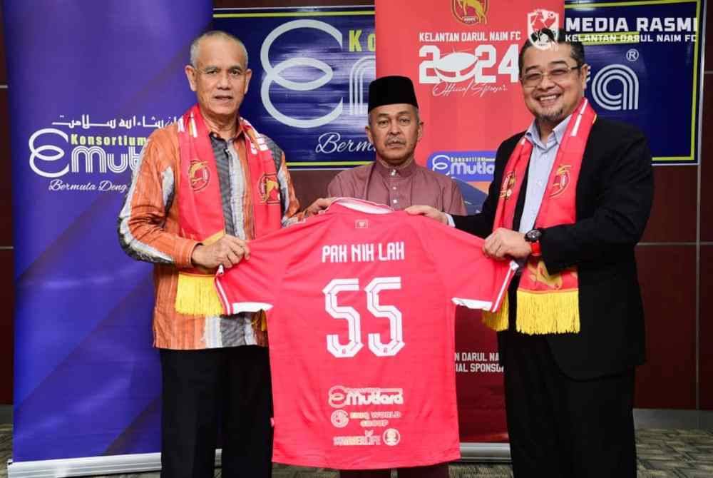 Che Ibrahim (kiri) menerima jersi KDN FC daripada Rozi (kanan) sebagai simbolik penajaan bas kepada pasukan tersebut.