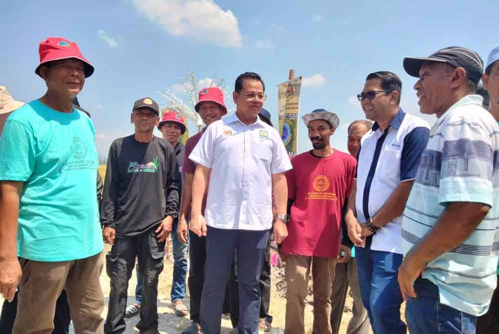 Azman (tengah) bertemu petani pada Majlis Dialog dan Perasmian Penuaian Tanaman Padi sempena Projek SMART Sawah Berskala Besar (SMART SBB) IADA Kemasin, Semerak pada Selasa.