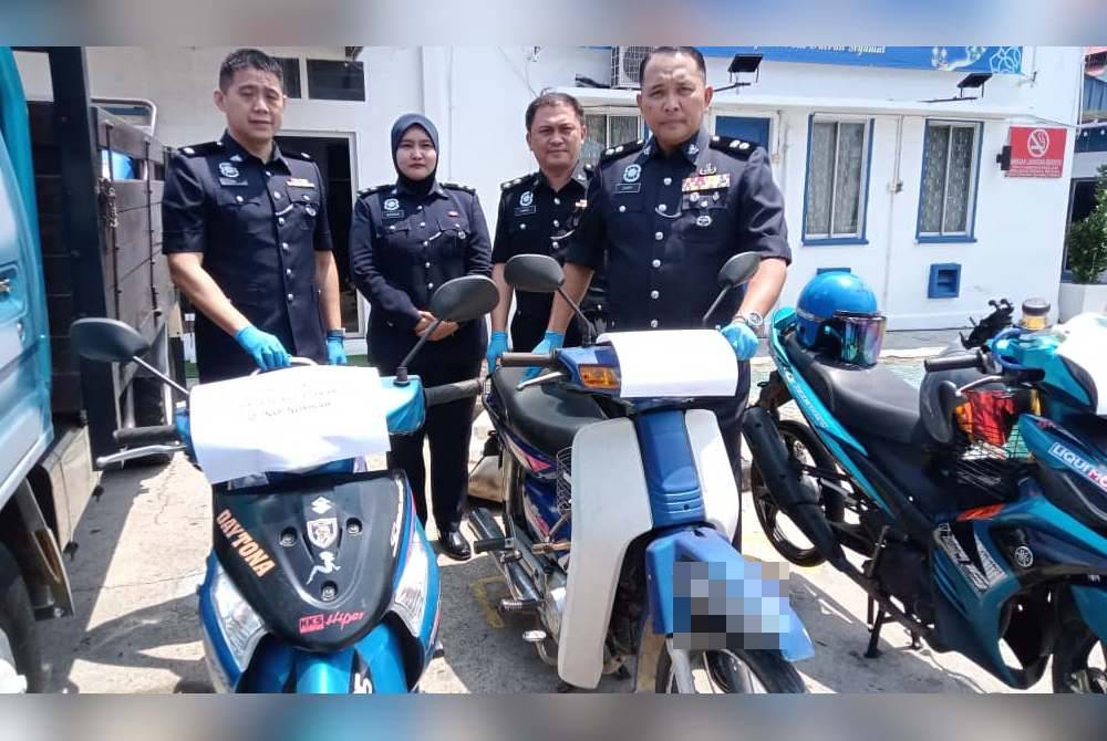 Ahmad Zamry (kanan) menunjukkan dua motosikal yang dilarikan suspek, selepas sidang akhbar di IPD Segamat, Segamat pada Selasa.