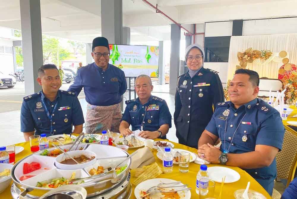 Nik Akhtar Ulhaq (berdiri, kiri) beramah mesra dengan tetamu semasa Rumah Terbuka Aidilfitri JIM Kelantan di Kota Bharu pada Rabu.