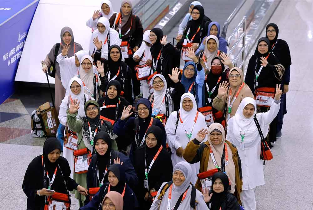 Para jemaah haji wanita kumpulan pertama melambaikan tangan sebelum berlepas ke tanah suci pada 12.05 malam ini dari Lapangan Terbang Antarabangsa Kuala Lumpur (KLIA) Terminal 1 malam Rabu. Foto Bernama